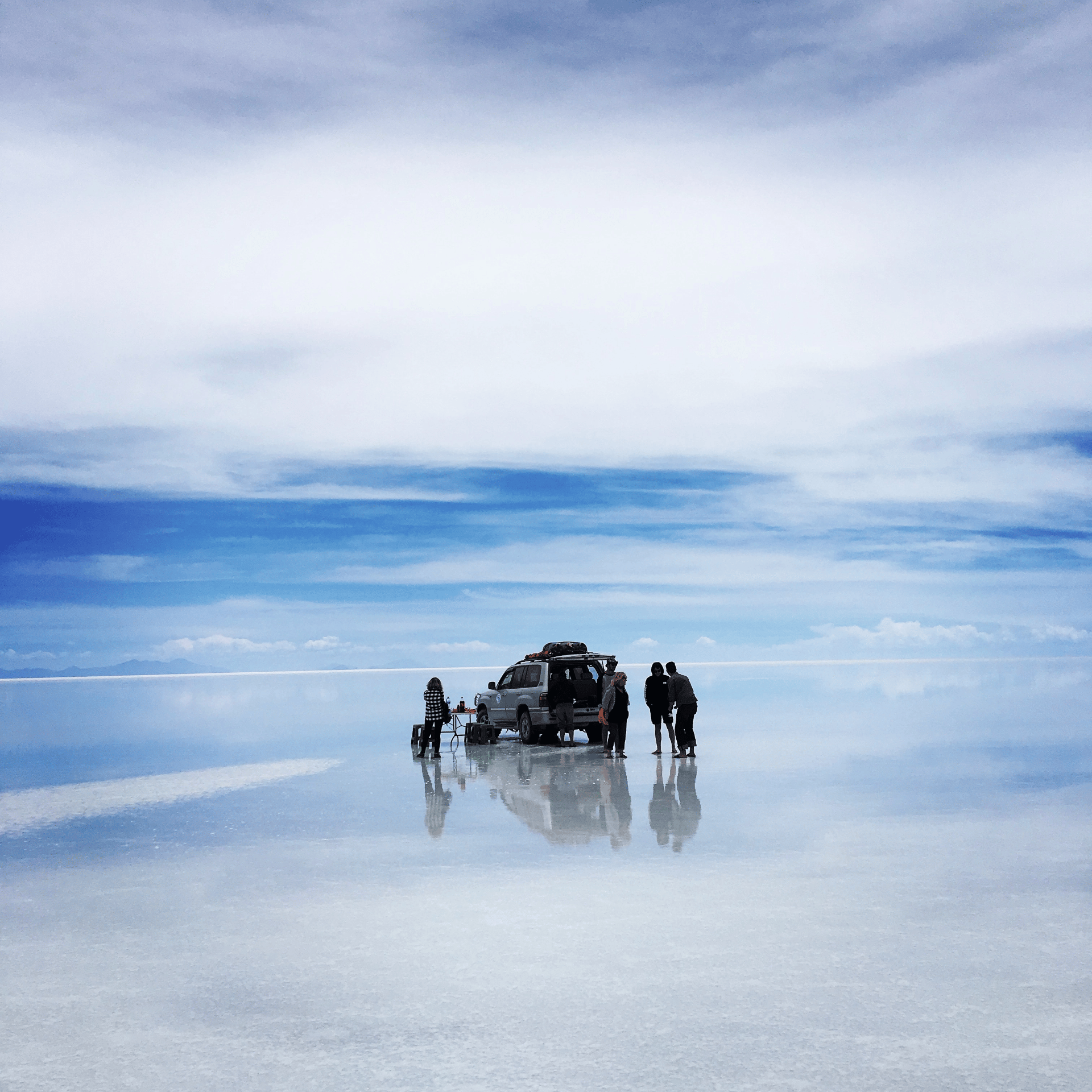 people with their car by the beach